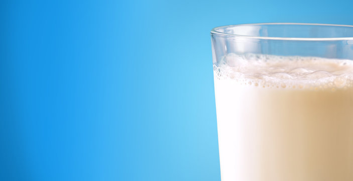 Glass full with milk on blue gradient isolated background