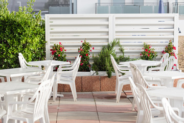 terrace with chairs and white plastic table beside the sea. Beach of Lido di Jesolo at adriatic Sea in a beautiful summer day Italy