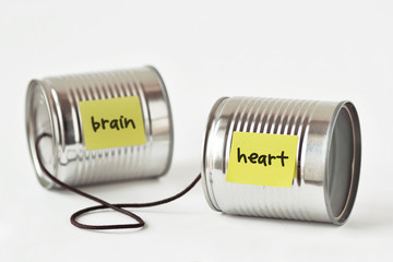 Tin cans phone with the words heart and brain written on paper note - Heart and brain connection concept