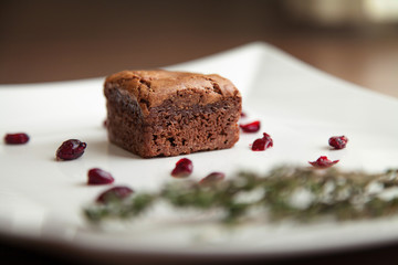  Cupcake on a white plate, decorated with berries and greens.