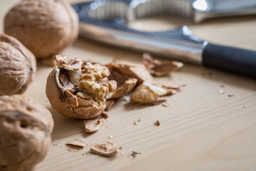 Fototapeta na wymiar Geknackte Walnuss, Nüsse und Nussknacker auf Küche Arbeitsfläche