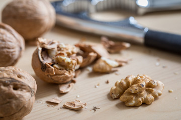 Fototapeta na wymiar Geknackte Walnuss, Nüsse und Nussknacker auf Küche Arbeitsfläche
