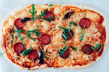 Pizza with sausage, arugula on white background.