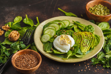 Green salad with spinach, cucumber, avocado, egg, flax and pumpkin seed. Food background. Detox Vegetarian Healthy Food Concept, copy space.