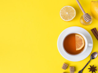 Flat lay on the yellow bright background Black tea Lemon Cinnamon Star Anise brown sugar jar of...