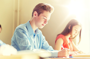 Fototapeta premium education, learning and people concept - group of students with books writing school test