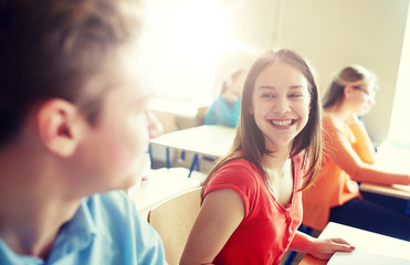 education, learning, communication and people concept - group of happy students talking at school break