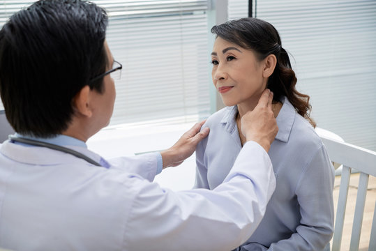 Confident middle-aged doctor wearing eyeglasses examining glands of senior patient while having appointment at modern office