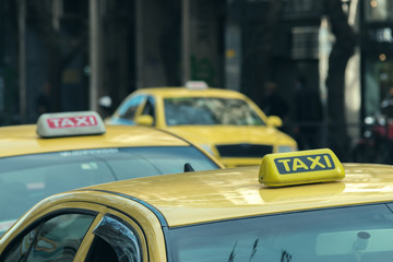 Details of yellow taxi cars on the city street.