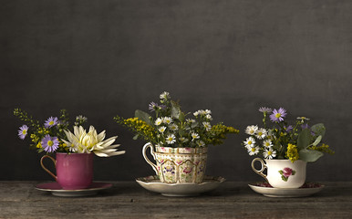 Flowers in a tea cup on a wooden table