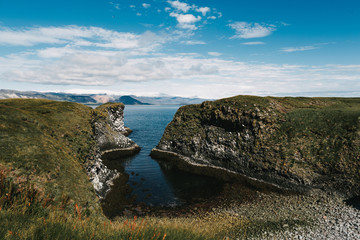 beautiful rocky coast and cold blue water in gatklettur, arnarstapi, iceland