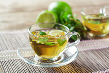cup of black tea with mint leaves on a wooden table