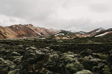 majestic landscape with rocky hills, snow and cloudy sky in iceland
