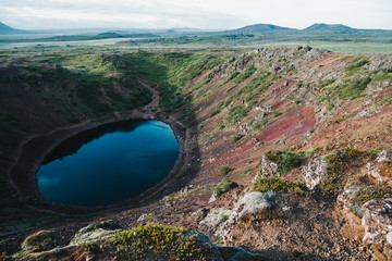 beautiful volcanic lake kerid and green hills in iceland