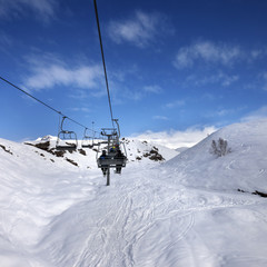 Fototapeta na wymiar Chair-lift and off-piste slope in sun day