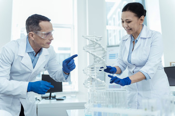 Study precisely. DNA diagnostic. Professional scientists studying dna model in a lab environment
