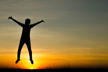 Silhouette women are jumping happily in the sunset.