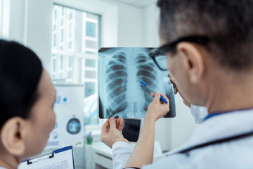 What is wrong here. Close up of radio scan in hands of professional doctors detecting problems