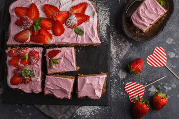 St.Valentine's Day Cake for breakfast with pink glaze and fresh strawberries. Dark background, summer berry dessert. Top view, copy space.