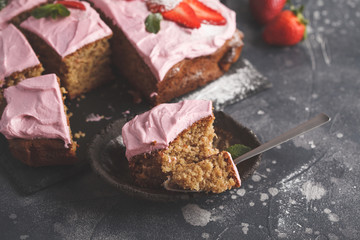 Yogurt pound cake for breakfast with pink glaze and fresh strawberries. Dark background, summer berry dessert, copy space.