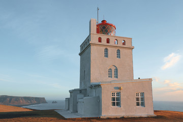 lighthouse at beautiful icelandic seashore at sunny day, vik dyrholaey, reynisfjara beach, iceland