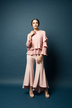 Attractive caucasian female model wearing elegant dress for work or dinner with blue background.Studio shot.
