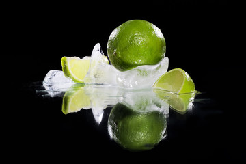macro photo of fresh greent lime frozen in ice isolated on black background