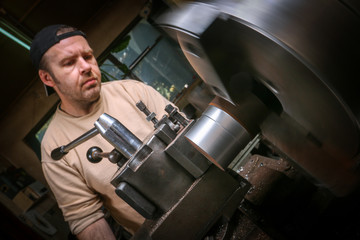 Metal worker working on lathe machine