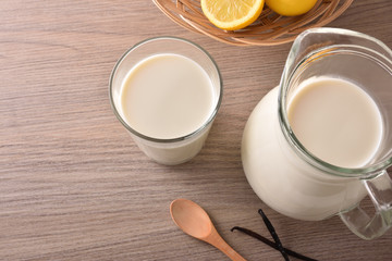 Obraz na płótnie Canvas Glass of milk and jug on wooden table top