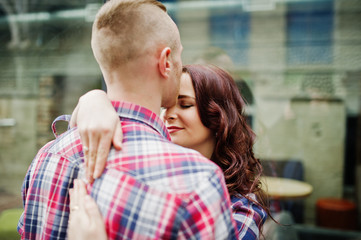 Stylish couple wear on checkered shirt in love together.