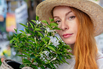 Woman in hat holding plant