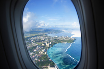 Plane window view with blue sky and sea