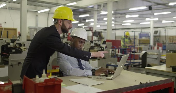 Manager and foreman in a factory discussing inventory.