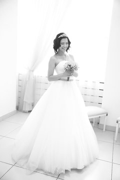black-and-white photo in retro style. smiling bride with bouquet before going to the altar