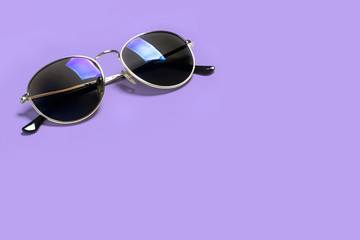 Stylish fashionable sunglasses isolated on a purple background. The concept of stylish poster,...