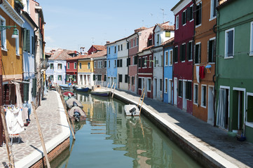 Fototapeta na wymiar Burano, Venice- View of the canal and colorful houses in a sunny day