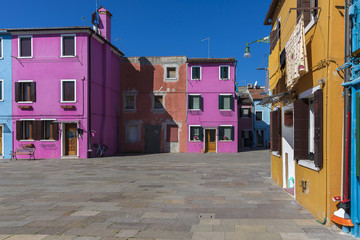 Fototapeta na wymiar Colorful buildings with vibrant colors and laundry drying in famous fishermen village on the island of Burano, Venice, Italy