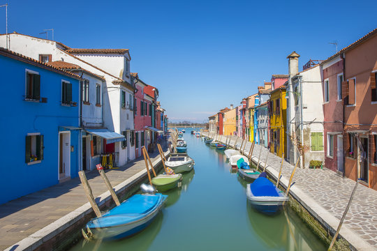 Typical canal with colorful facades with vibrant colors in famous fishermen village on the island of Burano, Venice, Italy © Melanie