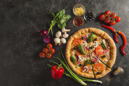 Flat Lay With Italian Pizza And Fresh Ingredients On Dark Surface