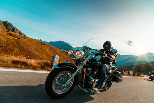 Fototapeta Motorcycle driver riding japanese high power cruiser in Alpine highway on famous Hochalpenstrasse, Austria.