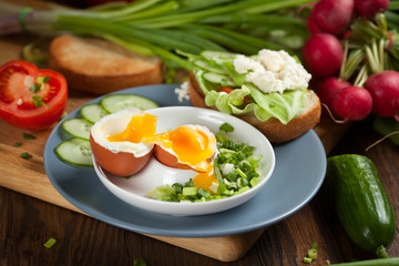 Boiled egg with crunchy bread and healthy vegetables for breakfast