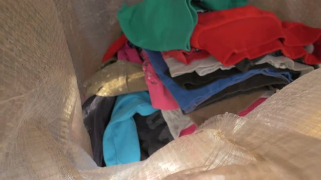 Putting clothes in a raffia sack