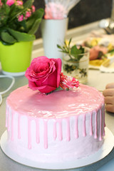 Tasty pink homemade cake decorated by rose and macarons