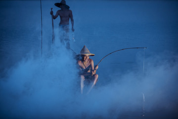 Fine art Fisherman father and son are fishing on the boat with fog at Mekong river this concept show life of Mekong river Thai and Laos.