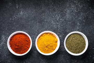 Various spices in a bowls on stone table.