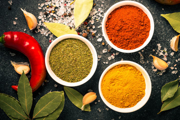 Various spices in a bowls on stone table.