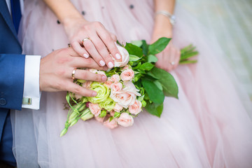 Obraz na płótnie Canvas Groom and bride with wedding rings and wedding bouquet