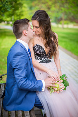 Bride and groom on bench in park