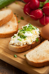 Summer sandwiches ingredients - cucumber, radish, tomato, mozzarella and eggs, white wood background, top view