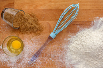 Baking ingredients - flour, sugar, egg on wood table.